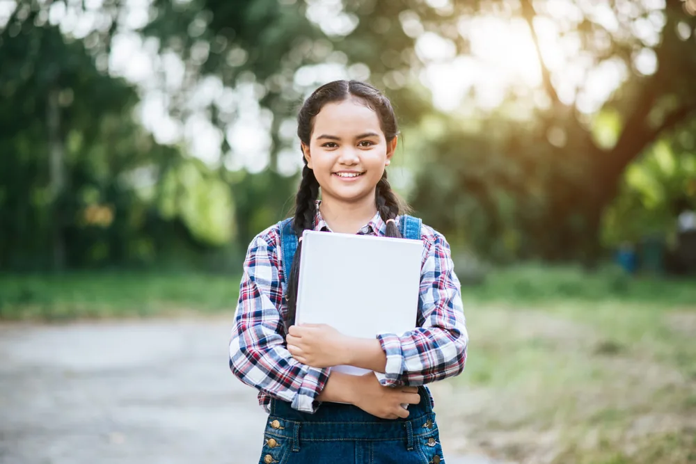 Happy child reading a Bible outdoors
