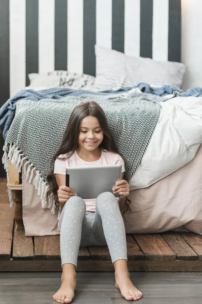 Smiling child using a tablet at home