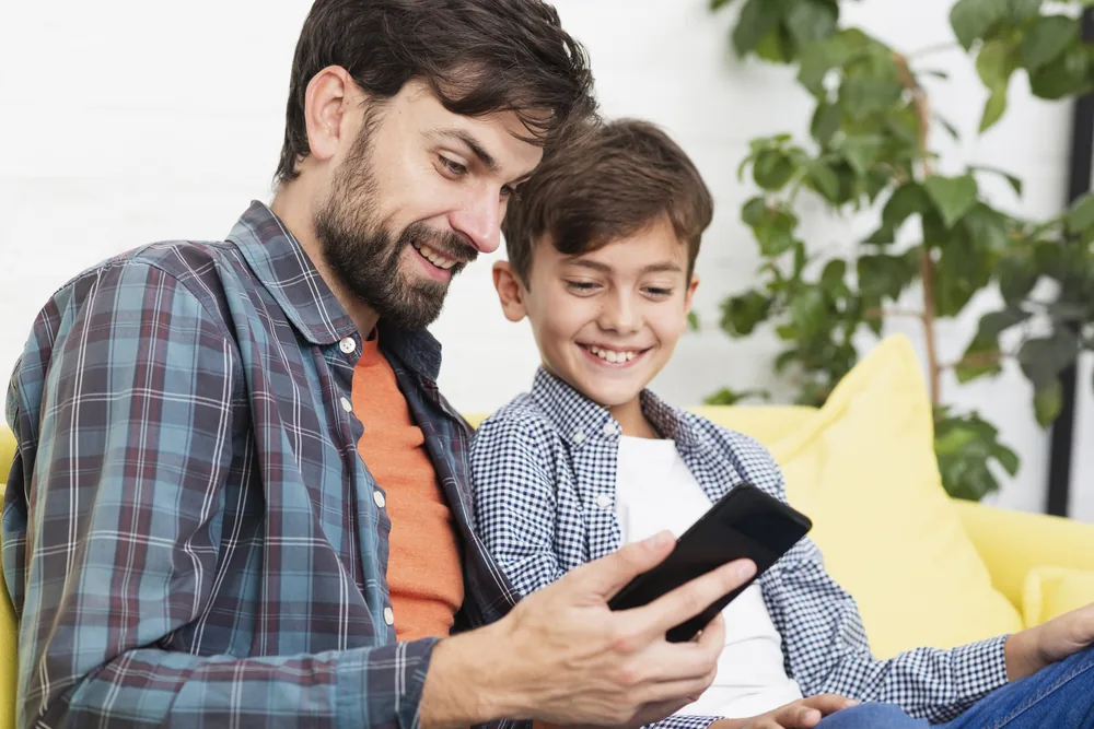 Parent smiling while looking at a phone